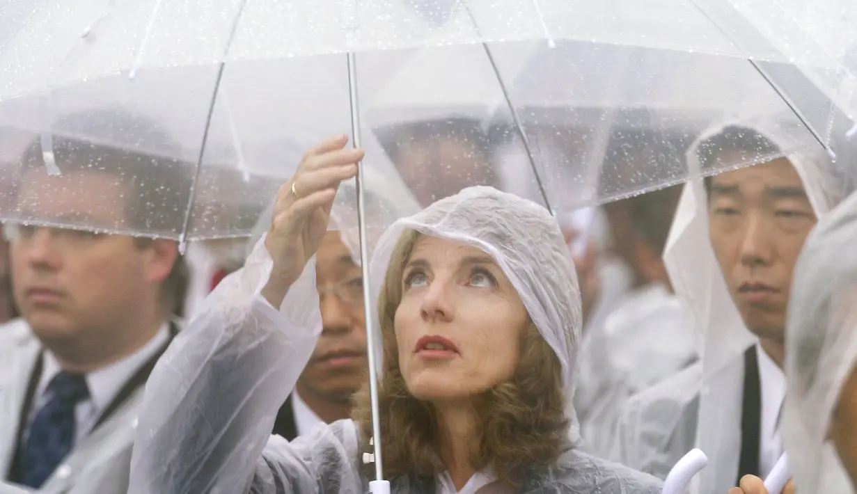 Seorang wanita tampak menggunakan jas hujan dan mpayung saat peringatan 69 tahun tragedi bom Hiroshima di Peace Memorial Park, Rabu (6/8/14). (REUTERS/Kyodo)