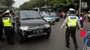 Petugas polisi lalu lintas memberi arahan kepada pengguna mobil saat pemberlakuan sistem ganjil genap di pintu masuk Gardu Tol Cibubur 2, Jakarta, Senin (16/4). (Liputan6.com/Faizal Fanani)