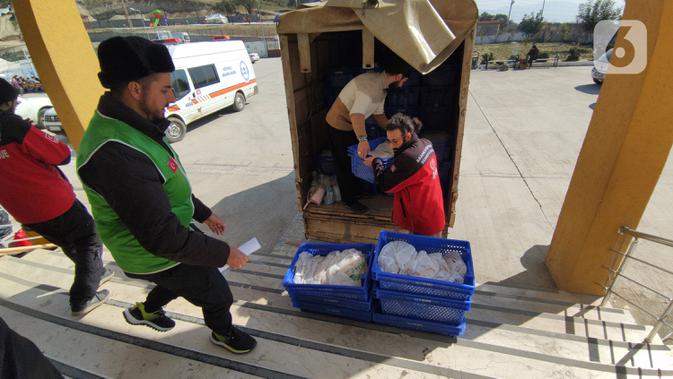 Anggota lembaga kemanusiaan non-pemerintah terbesar IHH saat menurunkan bantuan logistik dari truk di Kota Antakya, Provinsi Hatay, Turki (19/2/2023). 