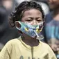 Seorang anak dengan masker mengikuti lomba memperingati HUT ke-75 RI di Kampung Nelayan, Cilincing, Jakarta, Senin (17/8/2020). Meski dilarang menggelar perlombaan akibat Covid-19, warga di Kampung Nelayan tetap mengadakan lomba 17-an walaupun hanya beberapa jenis. (merdeka.com/Iqbal Nugroho)