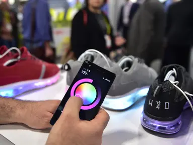 Pengunjung mencoba memprogram lampu sepatu Wize & Ope di Consumer Electronic Show (CES), Las Vegas (5/1). Dengan program dari smartphon, lampu pada bagian bawah sepatu Wize & Ope dapat dinyalakan. (AFP Photo/Frederic J. Brown)