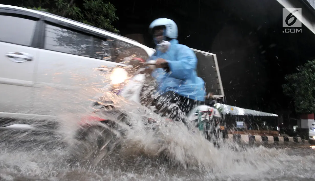 Pengendara sepeda motor menerobos banjir yang menggenangi Jalan DI Panjaitan, Jakarta, Senin (3/12). Banjir juga disebabkan adanya pengerjaan proyek Tol Becakayu yang berada di jalan tersebut. (Merdeka.com/ Iqbal S. Nugroho)