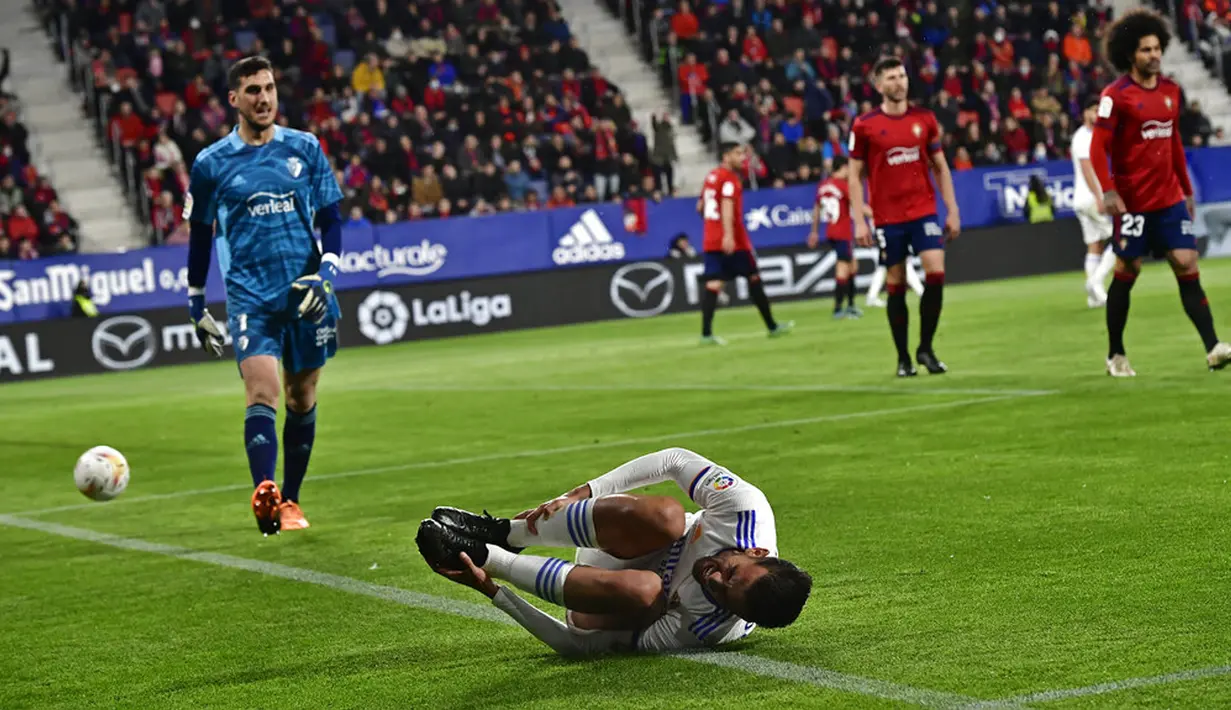 Pemain Real Madrid Dani Ceballos berbaring di lapangan saat melawan Osasuna pada pertandingan sepak bola La Liga Spanyol di Stadion El Sadar, Pamplona, Spanyol, 20 April 2022. Real Madrid menang 3-1. (AP Photo/Alvaro Barrientos)