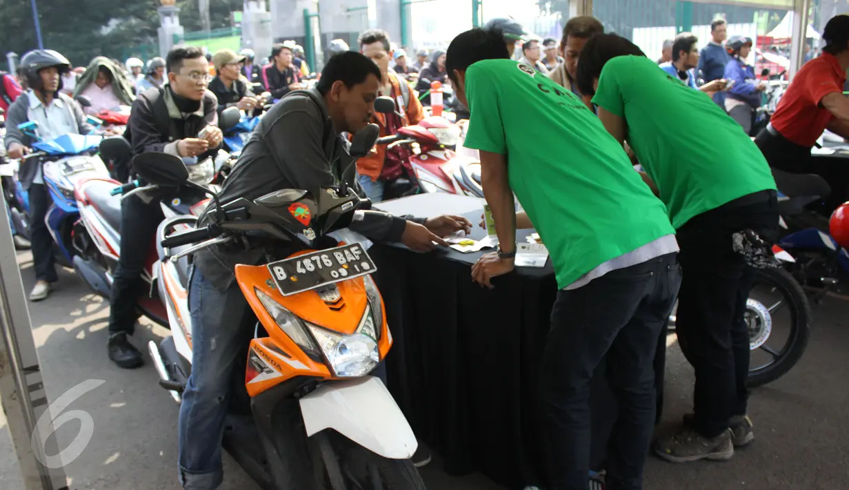 Sejumlah pemotor saat mengisi biodata pendaftaran untuk mendaftarkan diri sebagai pengojek GrabBike di Senayan, Jakarta, Rabu (12/8/2015). Lowongan kerja sebagai pengojek online merupakan peluang kerja baru bagi masyarakat. (Liputan6.com/Gempur M Surya)