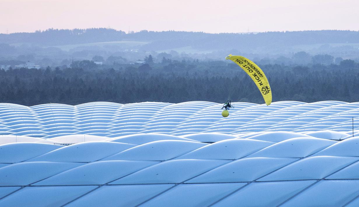 Seorang aktivis Greenpeace dengan menggunakan paraglider saat akan memasuki Stadion Allianz Arena, Muenchen. Belum bisa dipastikan aksi yang bisa dibilang berani tersebut ditujukan kepada pihak siapa. (Foto: AP/DPA/Matthias Balk)