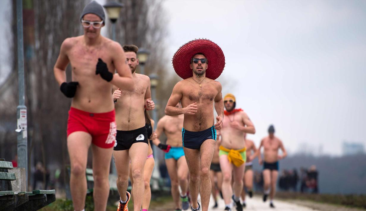 Peserta berlari saat mengikuti lomba Underpants Run di tepi sungai Danube di Beograd, Serbia (4/2). Dengan hanya mengenakan pakaian dalam para peserta tetap semangat mengikuti lomba dengan suhu mendekati nol derajat Celcius. (AFP Photo/Andrej Isakovic)