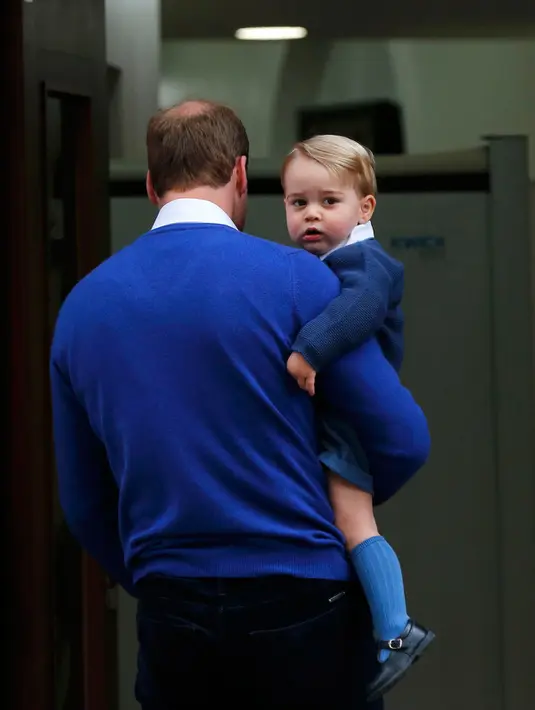 Pangeran William menggendong George, untuk menjenguk ibu dan adik perempuannya di Lindo Wing RS St Mary, London, Sabtu (2/5/2015). George pertamakalinya diajak bertemu adik kecilnya yang baru lahir. (REUTERS/Suzanne Plunkett)