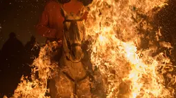 Masyarakat Desa San Bartolomeo de Pinares merayakan Hari Santo Antonius dengan menerobos api sambil kuda, Spanyol, Senin (16/1). Walau ekstrem, tradisi tersebut sudah berlangsung lebih dari 500 tahun yang lalu. (AFP Photo/ PIERRE-PHILIPPE Marcou)