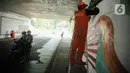 Beberapa petugas PPSU berbagi tugas dengan melukis mural pada bagian-bagian tembok kolong Semanggi. (Liputan6.com/Faizal Fanani)