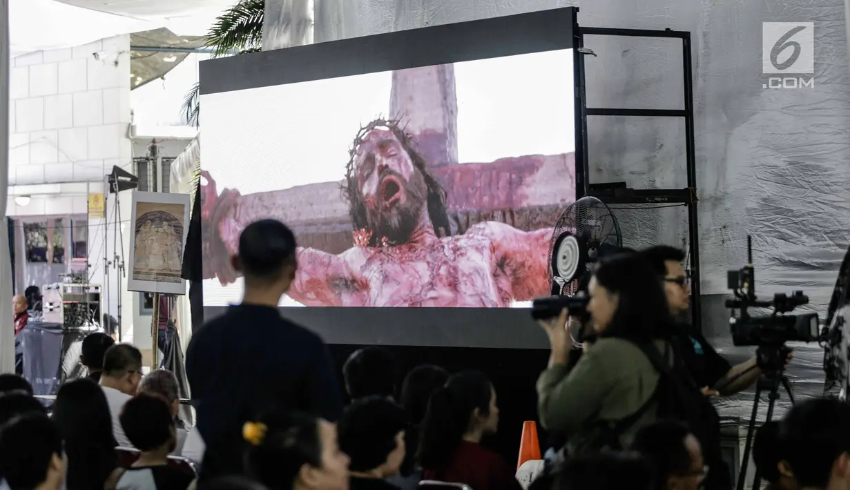 Jemaat khusyuk menyaksikan pemutaran film tentang penyaliban Yesus di Gereja Katedral, Jakarta, Jumat (30/3). Prosesi di antaranya ketika Yesus disalibkan, wafat, lalu dimakamkan. (Liputan6.com/Faizal Fanani)