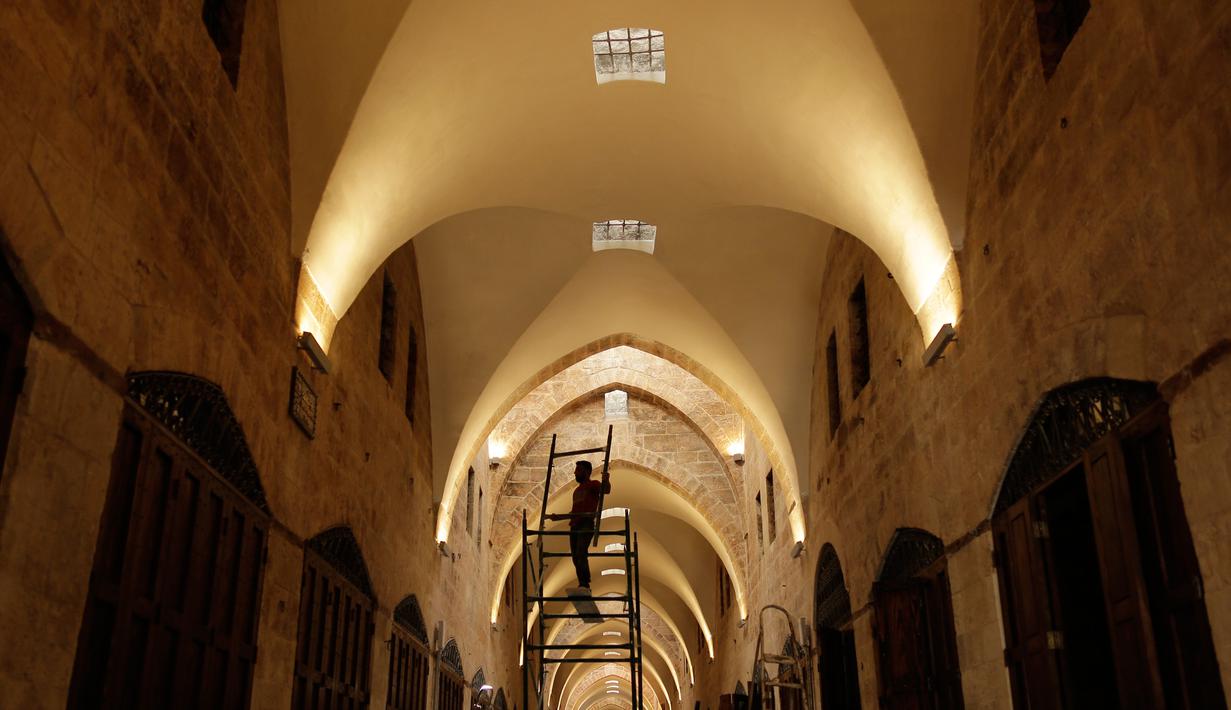 Pekerja merenovasi Pasar al-Saqatiyah yang baru saja direnovasi di Kota Tua Aleppo, Suriah, Sabtu (27/7/2019). Kendati sebagian besar pasar masih tutup setelah pertempuran besar tiga tahun lalu, kegiatan ekonomi perlahan mulai tumbuh di kota terbesar di Suriah tersebut. (AP Photo/Hassan Ammar)