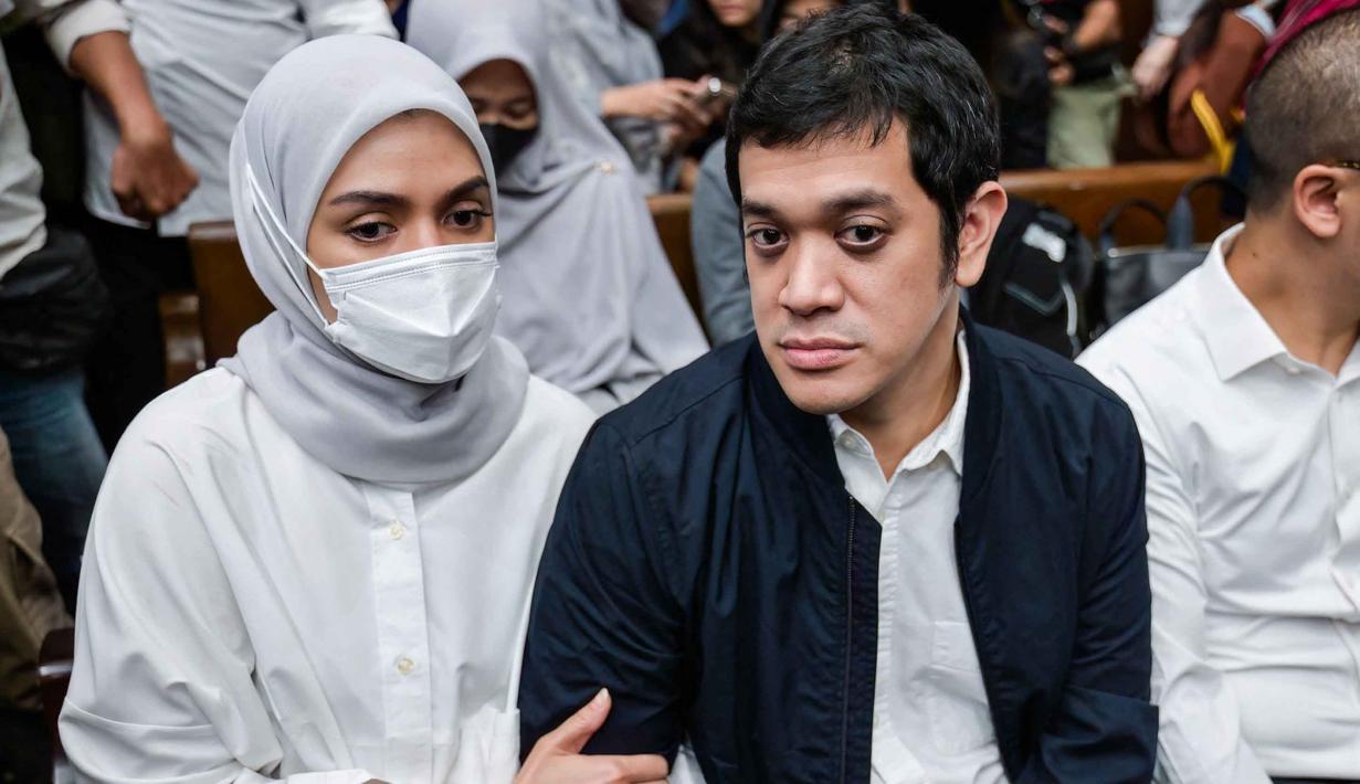 Sebelumnya, Muhammad Kerry Adrianto Riza didakwa melakukan pengaturan agar PT Jenggala Maritim Nusantara (JMN), perusahaan miliknya, memenangkan pengadaan sewa kapal dalam kerja sama dengan Pertamina. Tampak dalam foto, mantan Wakil Direktur Optimalisasi Produk di PT Kilang Pertamina Internasional, Muhammad Kerry Adrianto Riza (kanan), yang juga putra pengusaha Riza Chalid, didampingi istrinya Atya Sardadi (kiri), sesaat sebelum mengikuti sidang pembacaan vonis di Pengadilan Tindak Pidana Korupsi, Jakarta, Kamis 26 Februari 2026. (BAY ISMOYO/AFP)
