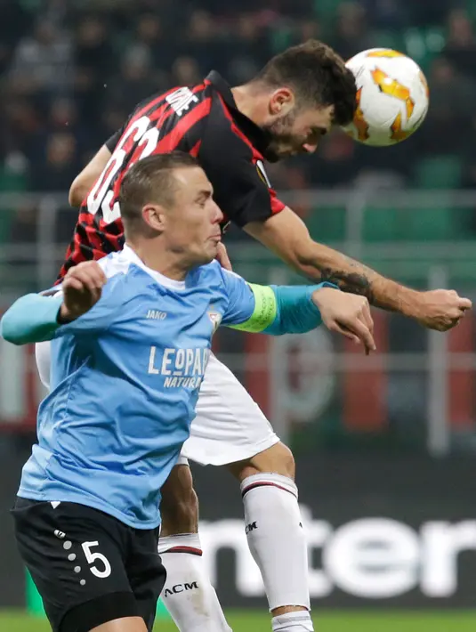 Pemain AC Milan, Patrick Cutrone berebut bola udara dengan Tom Schnell asal F-91 Dudelange saat bertanding dalam laga kelima Grup F Liga Europa di Stadion San Siro, Milan, Italia, Kamis (29/11). AC Milan menang 5-2. (AP Photo/Luca Bruno)