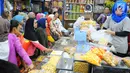 Pedagang kue kering melayani pembeli di Pasar Jatinegara, Jakarta, Senin (27/5/2019). Jelang Idul Fitri 2019, banyak warga berburu makanan ringan seperti kue kering untuk jamuan di hari raya. (Liputan6.com/Angga Yuniar)