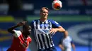 Winger Arsenal, Nicolas Pepe berusaha berebut bola dengan pemain Brighton & Hove Albion, Dan Burn pada lanjutan pertandingan Liga Inggris di The American Express Community Stadium, Sabtu (20/6/2020). Sempat unggu lebih dahulu, Arsenal justru tumbang 1-2 di tangan Brighton. (Mike Hewitt/Pool via AP)
