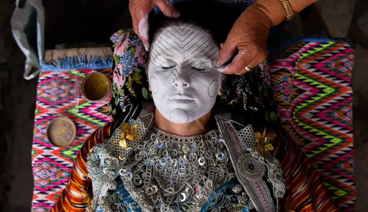 Wanita Kosovo, Sheqerie Buqaj saat menerima lukisan wajah tradisional di Desa Kukaj, Kosovo, Rabu (5/9). Para pengantin wanita akan dilukis wajahnya dengan berbagai warna. (ARMEND NIMANI/AFP)