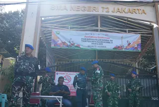 Penjagaan untuk memastikan tidak ada ancaman lanjutan pasca-ledakan dan menjaga situasi tetap aman dan kondusif. Tampak dalam foto, personel militer berjaga di gerbang sebuah sekolah setelah ledakan di Jakarta, Indonesia, Minggu, 9 November 2025. (AP Photo/Achmad Ibrahim)