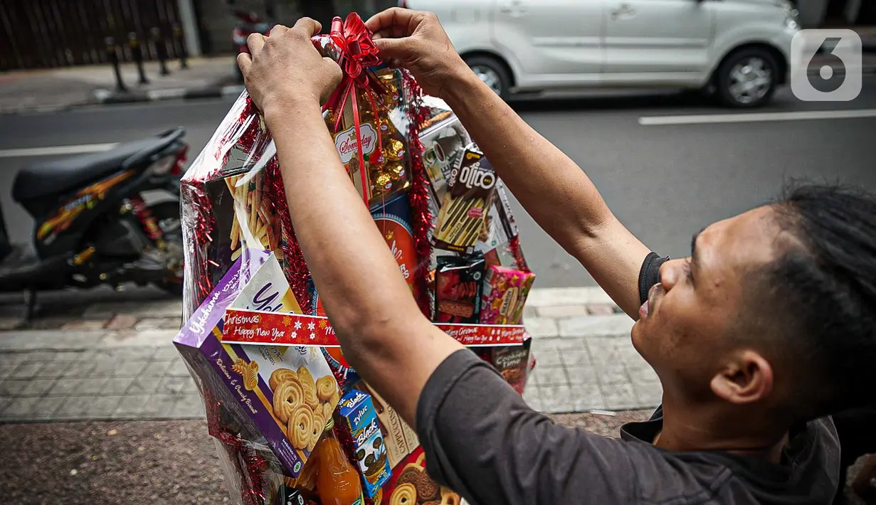 Pedagang merapikan parsel Natal siap kirim di Pasar Barito, Jakarta, Kamis (23/12/2021). Pedagang mengakui penjualan parsel sebagai hantaran Natal mulai ramai. Parsel yang paling banyak diminati adalah parsel makanan dengan harga mulai dari Rp 100.000 hingga Rp 800.000. (Liputan6.com/Faizal Fanani)