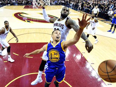 Pemain Cavaliers, LeBron James #23 menghalau tembakan pemain Warriors, Stephen Curry #30 pada game ke-6 Final NBA di Quicken Loans Arena, Jumat (17/6/2016) WIB. (Mandatory Credit: Bob Donnan-USA TODAY Sports)