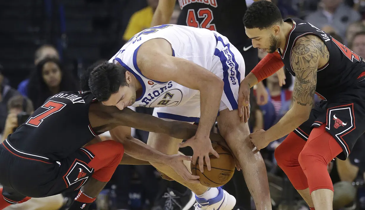 Pemain Golden State Warriors, Zaza Pachulia (tengah) berusaha keluar dari kepungan pemain Chicago Bulls pada laga NBA basketball game di Oracle Arena, Oakland, (24/11/2017). Warriors menang 143-94. (AP/Jeff Chiu)