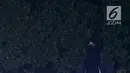 Seorang perempuan bercadar hitam dengan kabel menjuntai di tangan berusaha mendekat Gedung Bawaslu, Jakarta, Rabu (22/5/2019). Perempuan misterius yang berjalan sendiri tanpa massa ini mengenakan baju gamis warna hitam. (Liputan6.com/Immanuel Antonius)