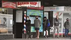 Para pria antre untuk memotong rambut di luar barber shop di Melbourne, Australia, Senin (19/10/2020). Warga Kota Melbourne, pada Senin (19/10), akhirnya bisa bernafas lega saat sejumlah pembatasan dilonggarkan setelah lockdown tahap keempat yang ketat selama sekitar 100 hari. (William WEST/AFP)