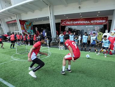Legenda Timnas Indonesia, Evan Dimas (kiri) berebut bola dengan pemain Timnas Indonesia U-17, Muhammad Mierza (kanan) dalam acara coaching clinic bersama Nagoya Grampus di Garuda Store, GBK, Senayan Jakarta, Jumat (26/06/2025) pagi WIB. (Bola.com/Bagaskara Lazuardi)