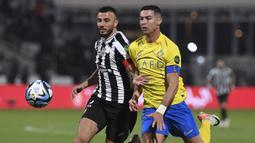 Pemain Al Nassr, Cristiano Ronaldo (kanan), berebut bola dengan pemain Al Shabab, Iago Santos, dalam laga perempat final King's Cup Arab Saudi 2023 yang digelar di Al Shabab Club Stadium, Selasa (12/12/2023) dini hari WIB. (AFP/Str)