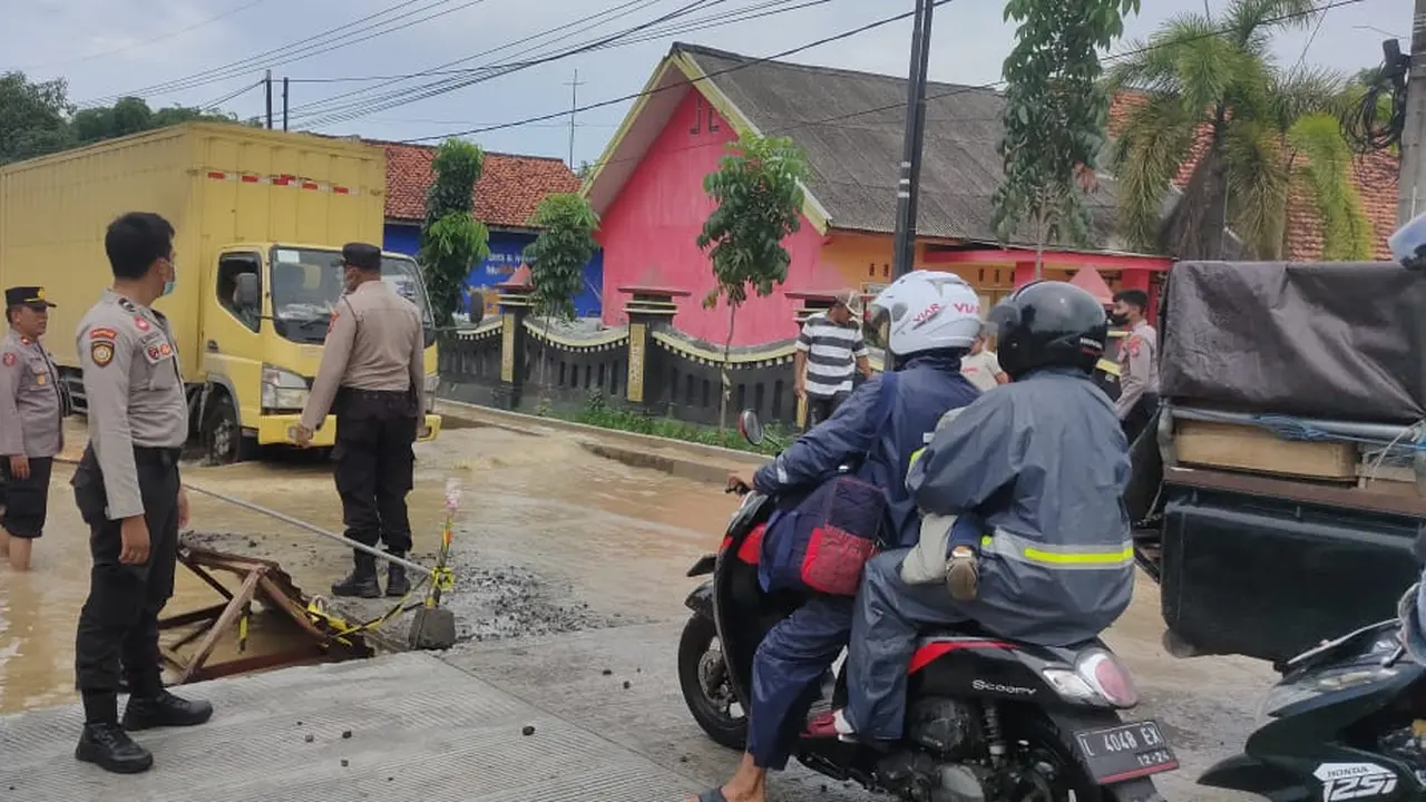 Polisi mengatur lalu lintas akibat banjir luapan sungai Blega Bangkalan. (Dian Kurniawan/Liputan6.com)