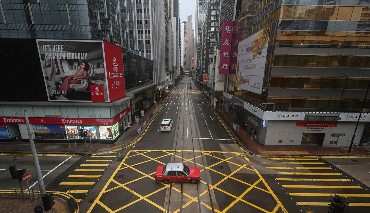 Sebuah taksi melaju di sepanjang jalan kosong di distrik Central saat Topan Wipha bergerak menuju Hong Kong pada 20 Juli 2025. (Peter PARKS/AFP)