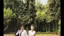 Dengan latar belakang rumput hijau yang asri, Dahlia Poland terlihat cantik dengan gaun pengantin putih didampingi sang suami yang gagah memakai jas pengantin hitam. Mereka nampak siap membangun masa depan bersama. (via instagram/@dahliaplnd)