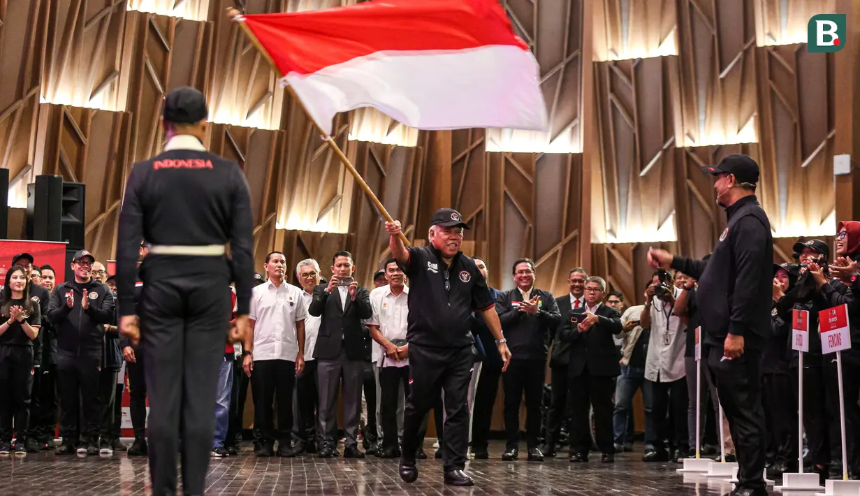 <p>Chef de Misson (CdM), Basuki Hadimuljono mengibarkan bendera merah putih saat pengukuhan Tim Indonesia untuk Asian Games 2022 yang berlangsung di Auditorium Kementerian PUPR, Jakarta, Selasa (19/09/2023). Sebanyak 413 atlet dari 30 cabang olahraga dikirim ke Asian Games kali ini. (Bola.com/Bagaskara Lazuardi)</p>