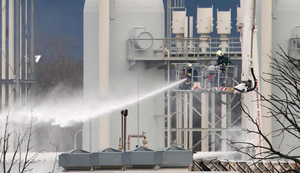 Petugas pemadam kebakaran menyemprotkan air di pusat pipa gas di Baumgarten, Austria, (12/12). Ledakan tersebut belum diketahui secara pasti apa penyebabnya. (AFP Photo/Joe Klamar)