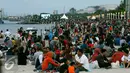 Ribuan pengunjung duduk dipinggir pantai menunggu pergantian tahun baru di Ancol, Jakarta, Sabtu (31/12). Tak hanya duduk-duduk, banyak pula yang bermain pasir dan berenang. (Liputan6.com/Angga Yuniar)