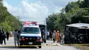 Jasad penumpang tergeletak di dekat bus wisata yang terbalik di jalan raya Mahahual di Quintana Roo, Meksiko, Selasa (19/12). Hingga kini, polisi masih menyelidiki penyebab terjadinya kecelakaan. (Novedades de Quintana Roo via AP)