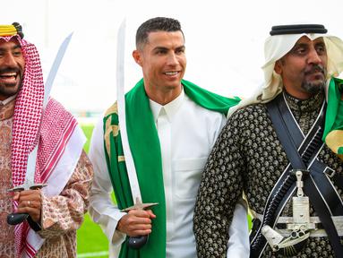 Pemain Al-Nassr, Cristiano Ronaldo (tengah) memakai gamis dan membawa pedang saat memperingati Hari Pendirian Kerajaan Saudi atau Founding Day di tempat berlatih pada Rabu (22/02/2023). (Twitter/@AlNassrFC)