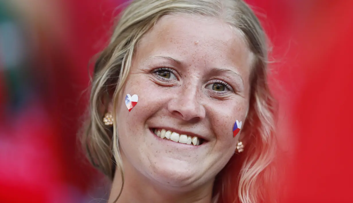Suporter cantik ini tersenyum saat menanti laga timnya pada grup D Piala Eropa 2016 melawan Kroasia di Stade Geoffroy-Guichard, Saint-Etienne, prancis, (17/6/2016). (REUTERS/Jason Cairnduff)