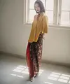 Untuk outfit kondangan sederhana, Binhpuse memadukan Tumeric Gold Blouse dengan kain batik. Menampilkan siluet yang elegan dan kecantikan yang eksotis dalam satu tampilan. (instagram/binhouse_official)