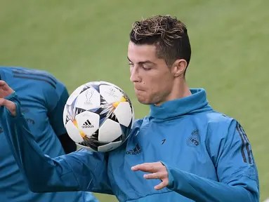 Pemain Real Madrid, Cristiano Ronaldo menahan bola dengan pundaknya saat sesi latihan di Allianz Stadium, Turin, Italia, Senin (2/4). Real Madrid akan menghadapi Juventus pada laga perempat final Liga Champions. (AFP PHOTO/Marco BERTORELLO)