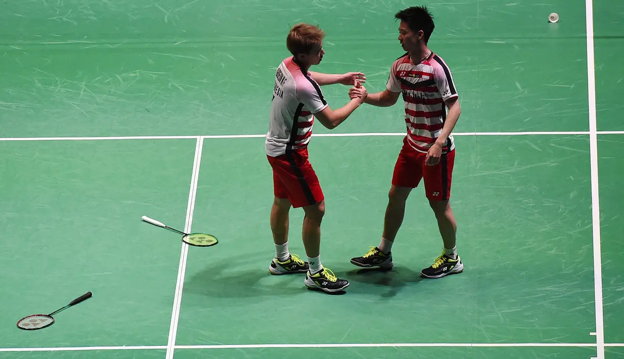 Ganda putra Indonesia, Kevin Sanjaya dan Marcus Gideon merayakan kemenangan saat semifinal All England di Birmingham, Sabtu (18/3/2018). Keduanya tahun ini akan berjuang untuk mempertahankan gelar juara All England. (AFP/Paul Ellis)