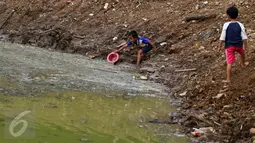 Anak-anak tampak ceria bermain di gundukan tanah pembangunan Waduk Brigif, Jagakarsa, Jakarta Selatan, Jumat (29/1/2016). Pemerintah DKI  menyebut jumlah ruang publik terpadu ramah anak di Ibu Kota belum memenuhi angka ideal.(Liputan6.com/Yoppy Renato)