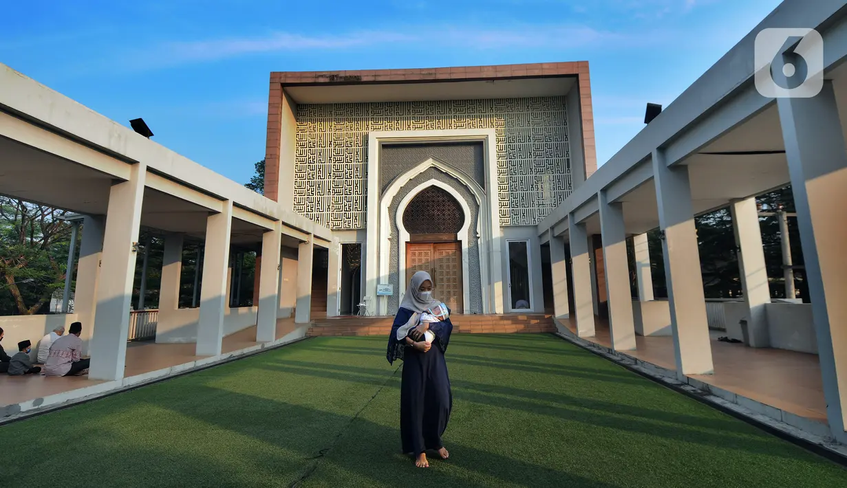 Seorang wanita menggendong bayi saat pelaksanaan salat Idul Adha 1442 H di Masjid Al-Madina Zona Madina, Parung, Bogor, Jawa Barat, Selasa (20/7/2021). Pelaksanaan salat Idul Adha dilakukan dengan menerapkan protokol kesehatan. (merdeka.com/Arie Basuki)