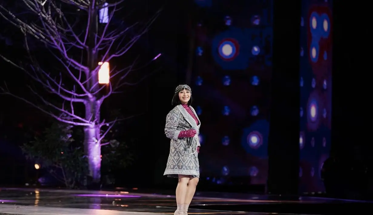 Penampilan Rinni Wulandari saat membawakan lagu “Dancing Queen” juga tak kalah memesona. Ia muncul dengan outer bergaya etnik yang dipadu dengan sequin turtleneck top warna pink. Penampilannya dipermanis dengan headpiece. [Instagram/rinni_w].