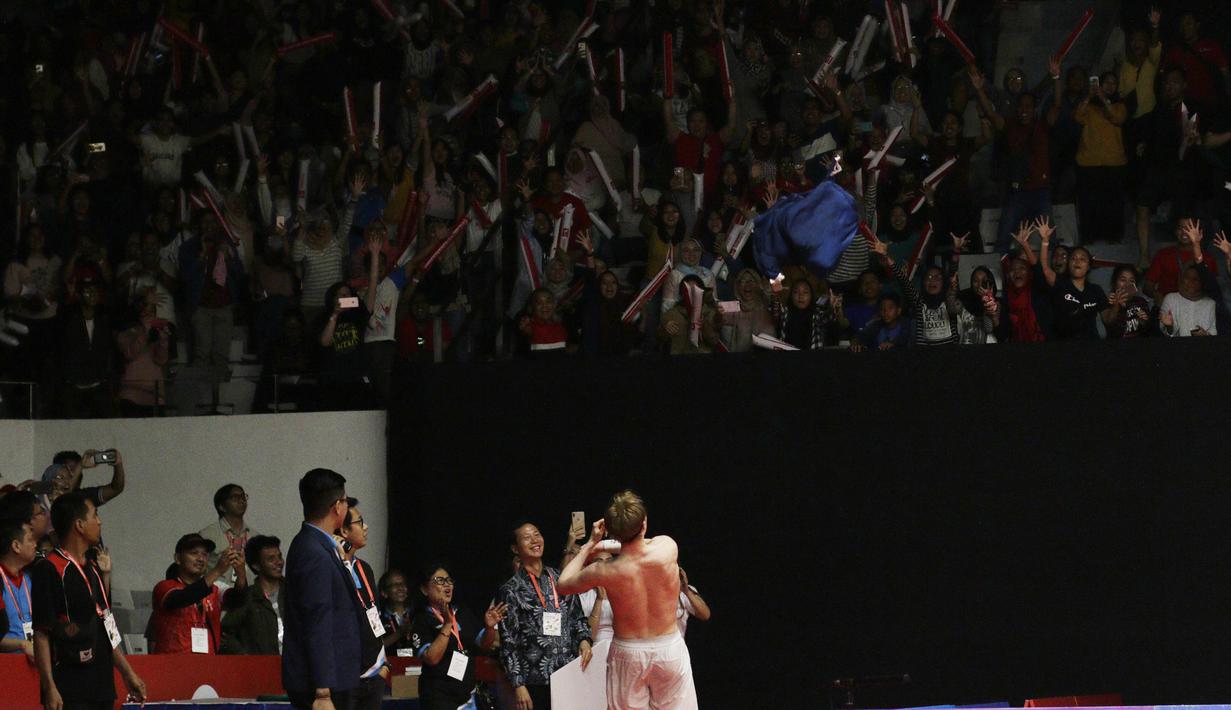 Pebulutangkis Denmark, Anders Antonsen, melempar baju ke arah penonton usai mengalahkan wakil Jepang, Kento Momota, pada laga Indonesia Masters 2019 di Istora, Jakarta, Minggu (27/1). Antonsen menang 21-16, 14-21, 21-16. (Bola.com/M Iqbal Ichsan)