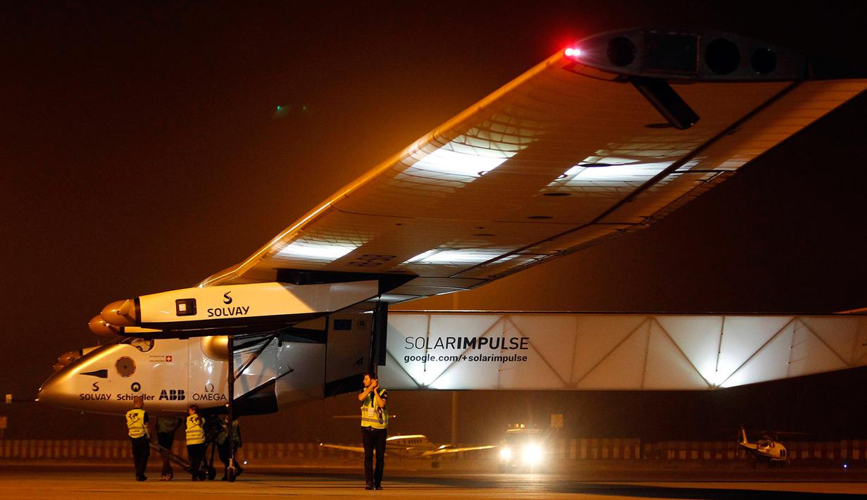 Salah satu teknisi  memegang pipa pelindung angin dari pesawat Solar Impulse 2 di bandara Ahmedabad, India, Rabu (11/3/2015). Pesawat buatan Swiss tersebut mendarat setelah menempuh perjalanan selama 15 jam.  (Reuters/Amit Dave)
