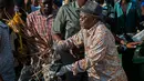 Presiden Tanzania, John Magufuli bergabung dengan warga untuk ikut ambil bagian dalam operasi pembersihan umum di kota utama Dar es Salaam, Rabu (9/12). Ini merupakan bagian dari acara untuk menggantikan perayaan hari kemerdekaan. (DANIEL HAYDUK/AFP)