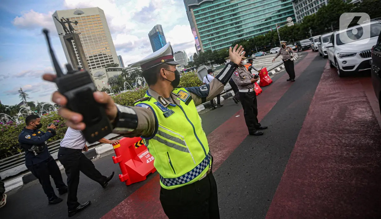 Petugas gabungan mengatur lalu lintas saat uji coba rekayasa lalu lintas di kawasan Bundaran HI, Jakarta Pusat, Senin sore (4/7/2022). Arus lalu lintas di sekitar Bundaran HI semakin padat dalam beberapa waktu terakhir hingga dilakukan rekayasa lalu lintas di sekitar lokasi. (Liputan6.com/Faizal Fanani)