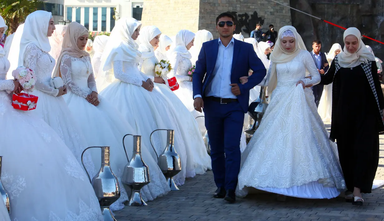 Pasangan yang baru menikah menghadiri perayaan Rusia City Day di Grozny, Rusia, (5/10). Sebanyak 199 pasangan menikah di Taman Bunga Grozny pada perayaan tersebut. (AP Photo / Musa Sadulayev)