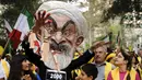 Max Saatchi berdiri dengan pengunjuk rasa lainnya sambil mengenakan topeng Presiden Iran Hassan Rouhani mengecam pelanggaran hak asasi manusia oleh pemerintah Rouhani di luar markas besar PBB, Manhattan, New York, AS (28/9/2015). (REUTERS/Darren Ornitz)