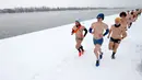 Para pelari ambil bagian dalam Underpants Run di tepi sungai Danube, Serbia pada 26 Januari 2019. Peserta berlari hanya dengan mengenakan pakaian dalam di tengah suhu yang mendekati 0 derajat Celcius. (AP/Darko Vojinovic)